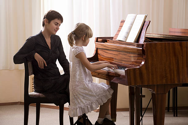 istock Girl And Teacher Playing Piano 534003133