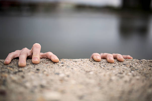 hände eines frau hält am rand der wand. - thumb stones stock-fotos und bilder