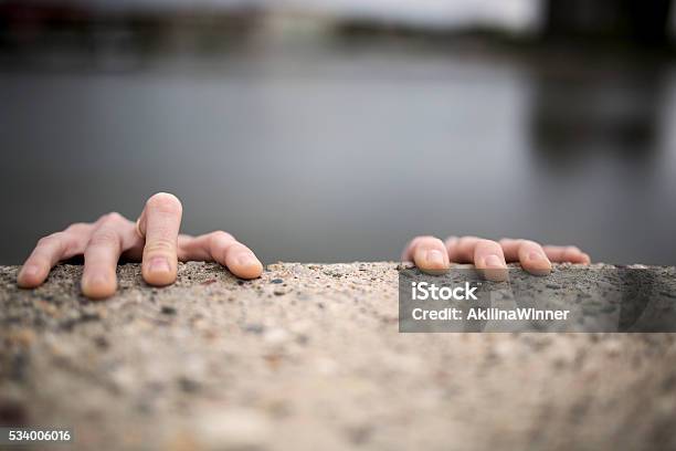 Hands Of A Woman Holding On Edge Of The Wall Stock Photo - Download Image Now - Wall - Building Feature, Surrounding Wall, Climbing