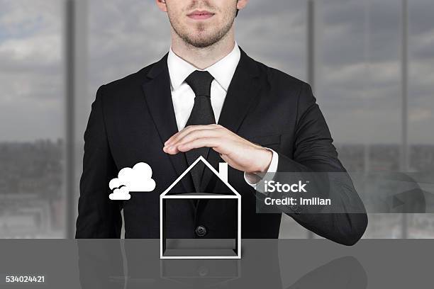 Businessman Holding Protective Hand Above Empty Building Symbol Stock Photo - Download Image Now