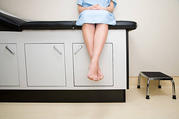 paciente sentado en el sofá de la sala de tratamiento - examination gown fotografías e imágenes de stock