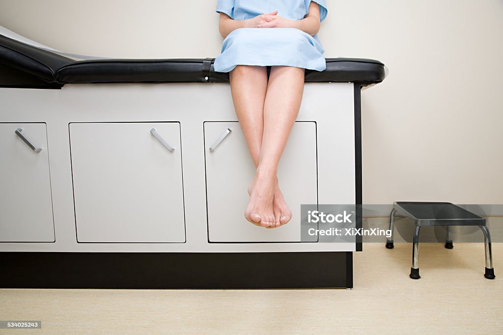 Patient sitting on treatment couch Doctor's Office Stock Photo
