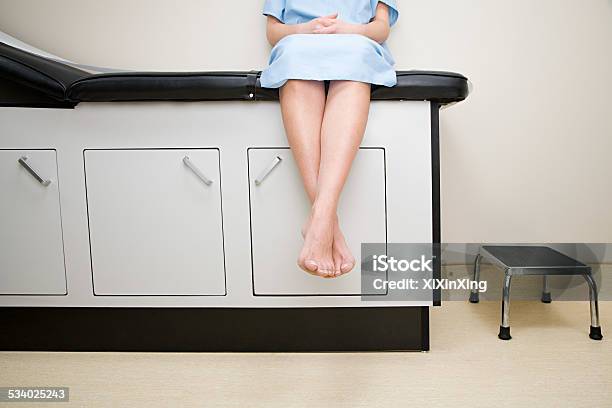 Patient Sitting On Treatment Couch Stock Photo - Download Image Now - Doctor's Office, Hospital Gown, Waiting