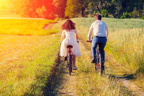 istock Young happy bride and groom ride bicycles 534028015