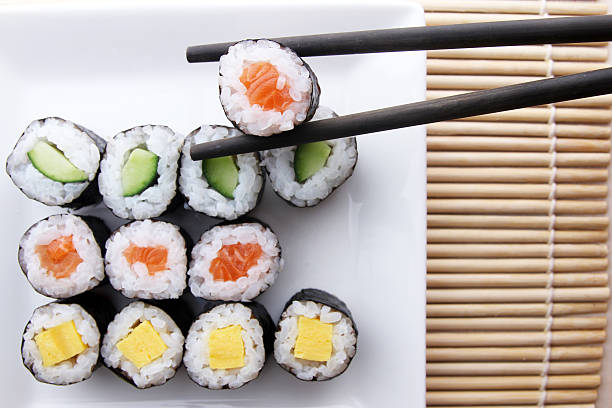 istock Chopsticks holding sushi from a plate of assorted sushi 534029223