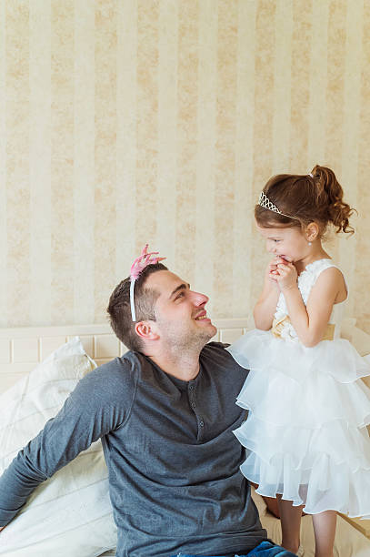 istock Cute girl putting a crown on her father head 534030536