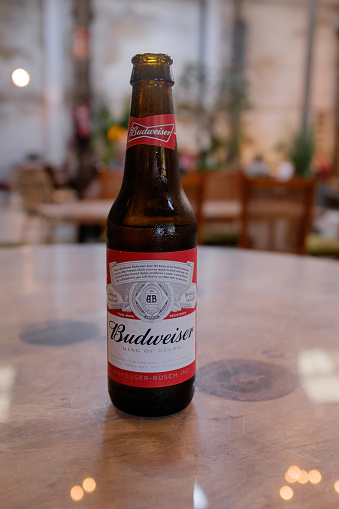 Valencia, Spain - May 24, 2016: ice cold bottle of open Budweiser, covered with water drops - condensation, in a bar setting. Budweiser is one of many beers made by Anheuser-Busch.