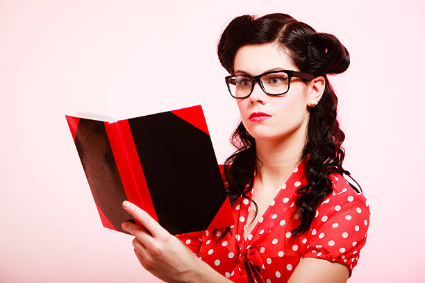 istock Retro. Pinup girl in eyeglasses reading book 534031763