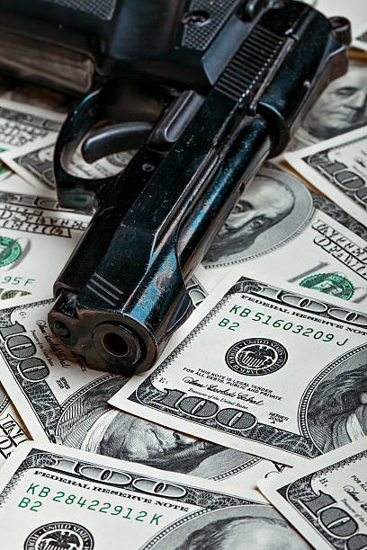istock money and gun.dollars 534032427