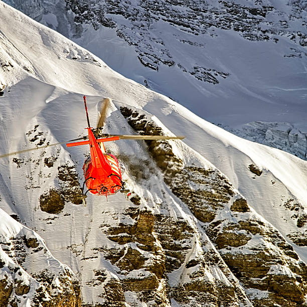 istock Red helicopter in flight in winter alps 534034529
