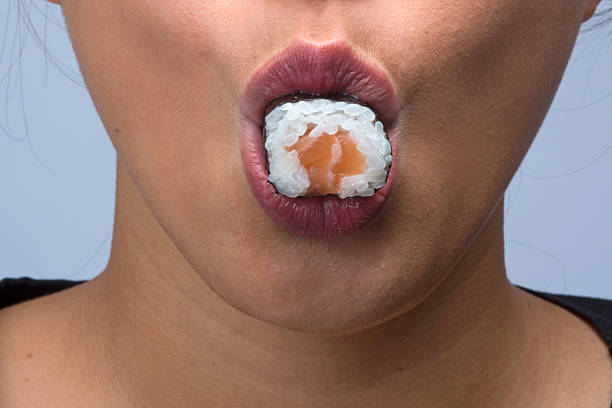 woman eating sushi stock photo