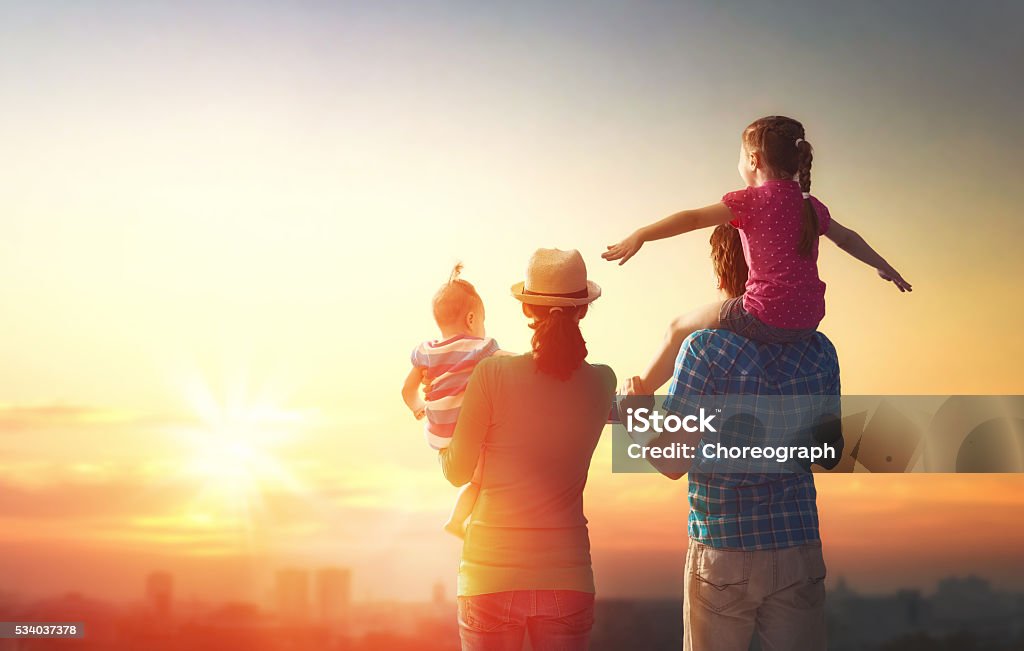 Familia feliz en la puesta de sol. - Foto de stock de Familia libre de derechos