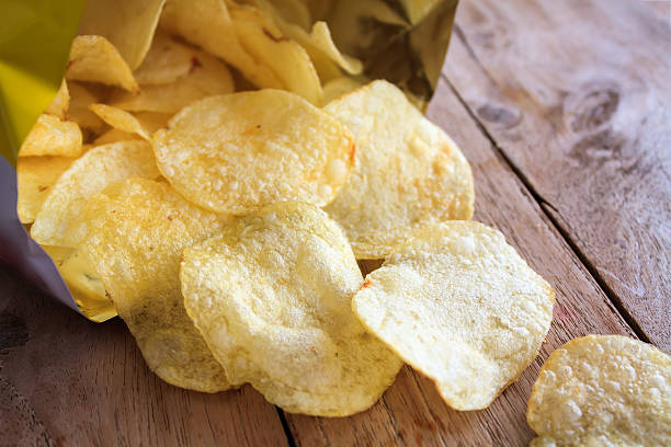 istock Opened pack of delicious potato chips on wood table 534038690