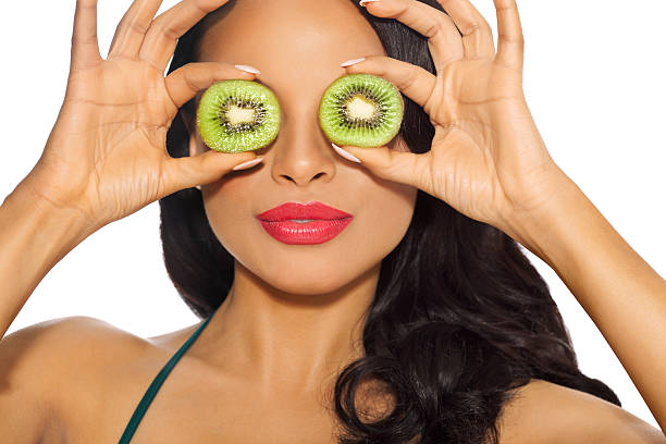 girl with kiwi slices - facial expression isolated lifestyles exoticism imagens e fotografias de stock