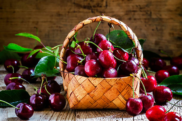 istock Sweet ripe cherries with leaves in a wicker basket 534046636