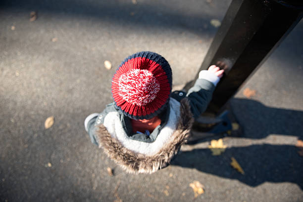 Lonely kid holding a post in central park, New York stock photo