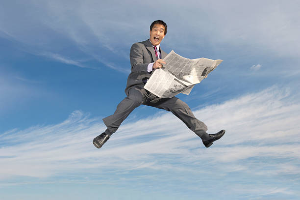istock Businessman Holding Newspaper Against Cloudy Sky 534046921