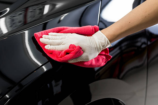 Car detailing series : Cleaning black car Closeup of hand cleaning black car polishing stock pictures, royalty-free photos & images