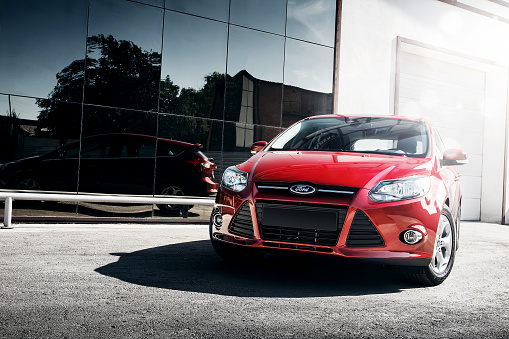 Engels, Russia - September 21, 2014: Red car Ford Focus III Sport standing in the city near mirror build at daytime