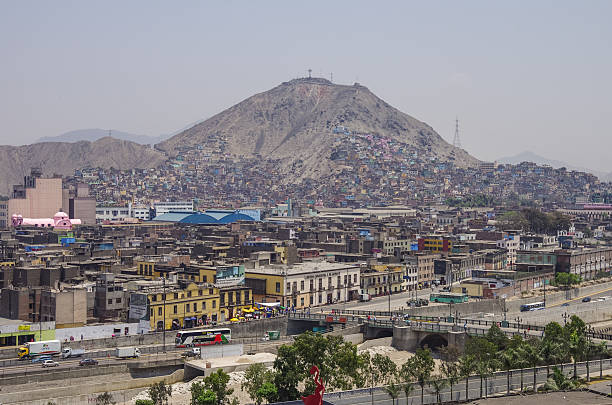 : Slums on the slope of hill San Cristobal Lima, Peru - December 31, 2013: Slums on the slope of hill San Cristobal and downtown on the northern side of the river Rimac. poverty mexico environment slum stock pictures, royalty-free photos & images