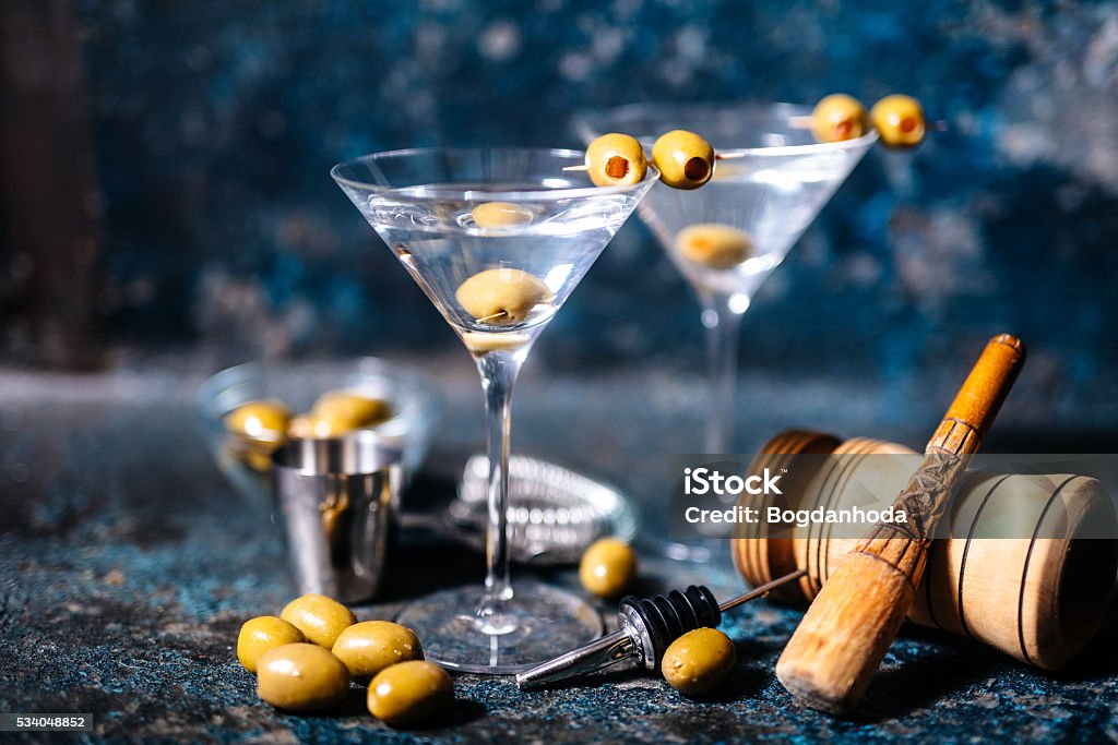 Martini cocktail drink with olives garnish and tools Martini cocktail drink with olives garnish and tools on rusty background Martini Stock Photo