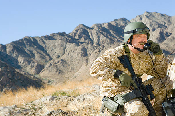 istock Soldier Using Telephone While Holding Rifle Against Mountain 534049161