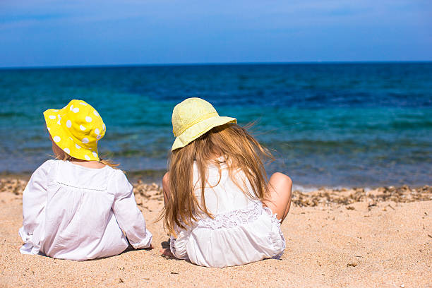 istock Adorable cute girls on white beach during vacation 534050647