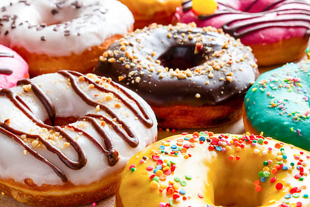 rosquillas en multicolored glaseados primer plano - sweet food fotografías e imágenes de stock