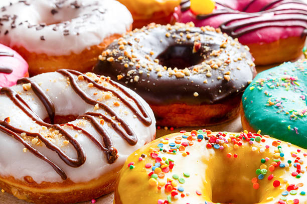 rosquinhas com glacê de multicolorida close-up - donut sweet food dessert snack - fotografias e filmes do acervo