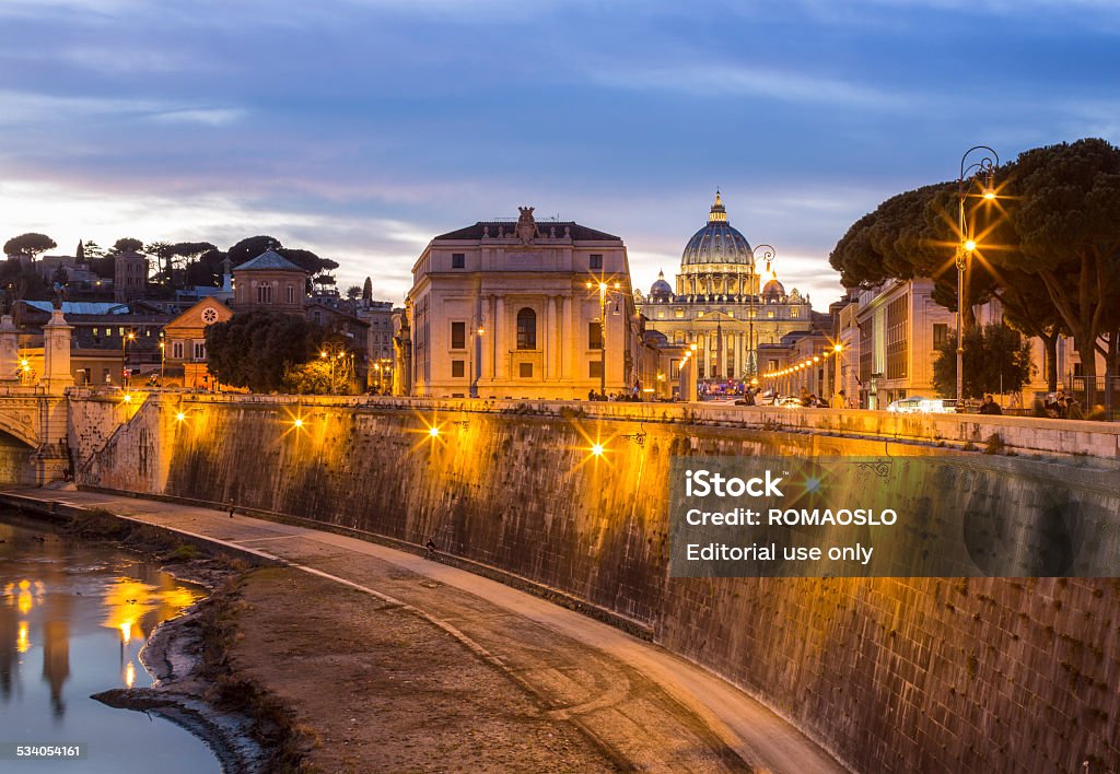 St. Peter's Basilica at sunset, Vatican Rome Italy Vatican Rome, Italy - January 24, 2015: St. Peter's Basilica with Christmas tree and the Tiber river at sunset seen from Ponte Sant Angelo 2015 Stock Photo