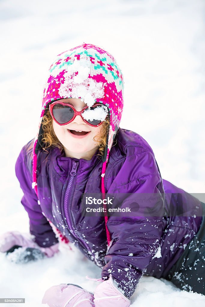 Little Girl With Snow on Her Face Little girl with snow on her hat and glasses after falling face-first into the snow. 2-3 Years Stock Photo