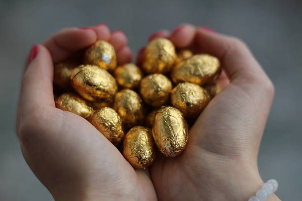 goldene eier im den händen – bild - animal egg gold human hand nest egg stock-fotos und bilder
