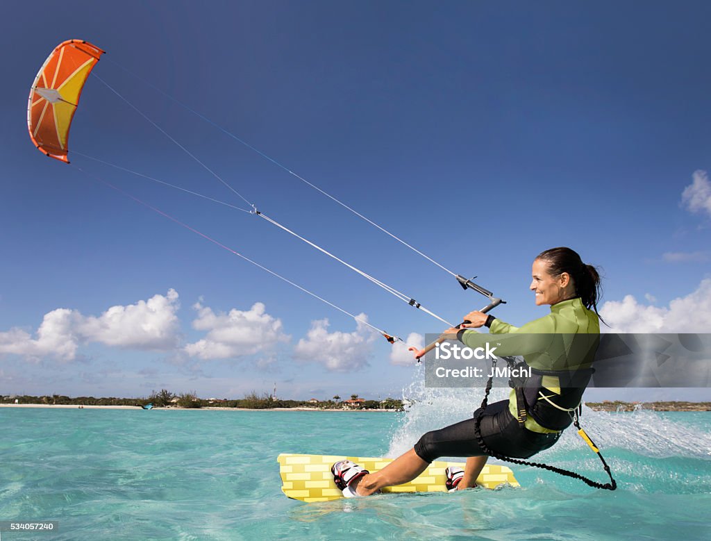Kite Boarding Woman in the Caribbean. An athletic woman kite boarding in the Caribbean. Kiteboarding Stock Photo
