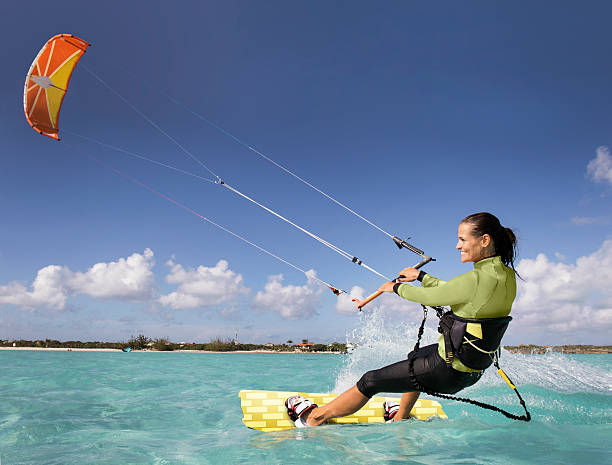Kite Boarding Woman in the Caribbean. An athletic woman kite boarding in the Caribbean. kiteboarding stock pictures, royalty-free photos & images