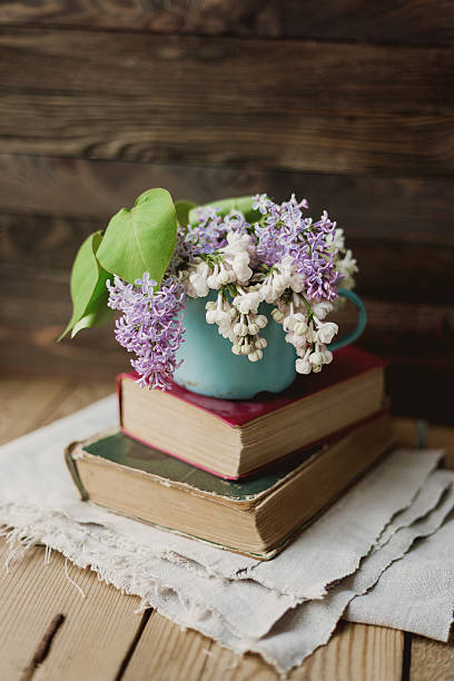 istock Two old books and rusty mug with lilac bouquet 534058596
