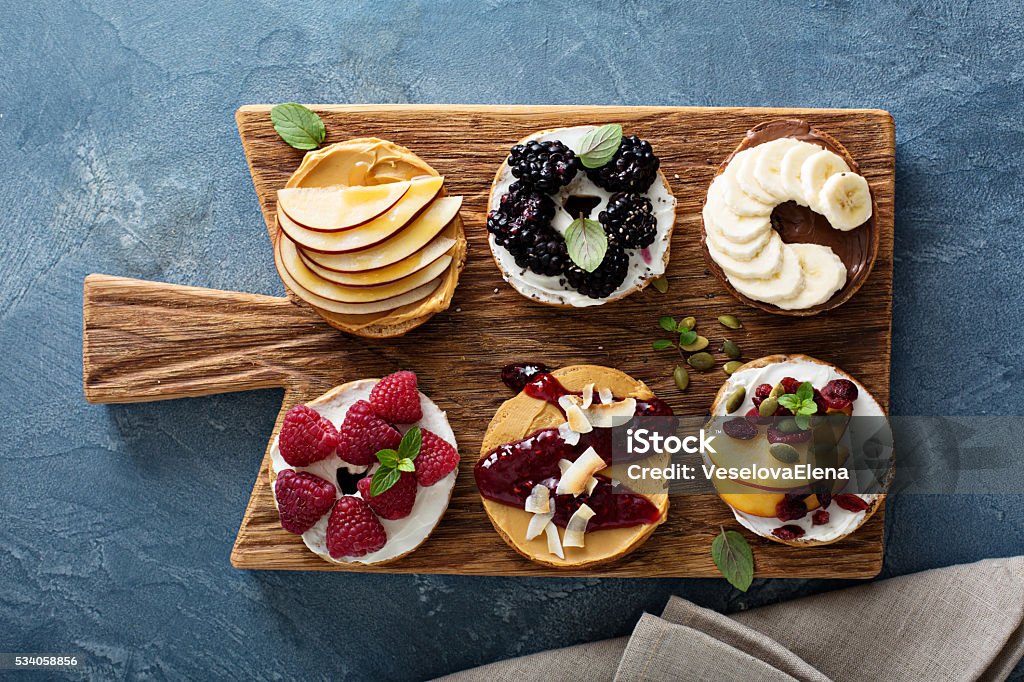 Variety of bagels on a board Variety of bagels with different toppings for breakfast on a board Baked Stock Photo