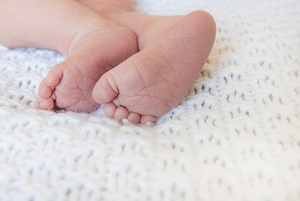 Baby feet on a white blanket stock photo