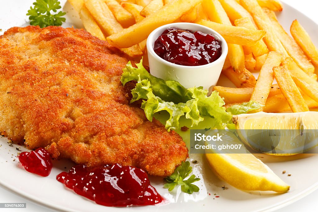 Pork chop, French fries and vegetables Fried pork chop with vegetables  2015 Stock Photo