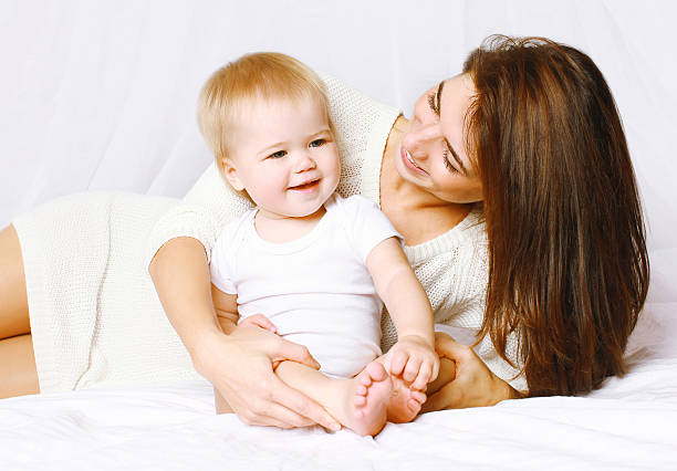 istock Happy mom and baby having fun in bed at home 534078603