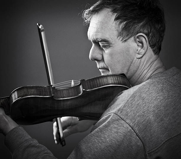 istock Happy Senior Man Playing a Violin or Fiddle. 534081139
