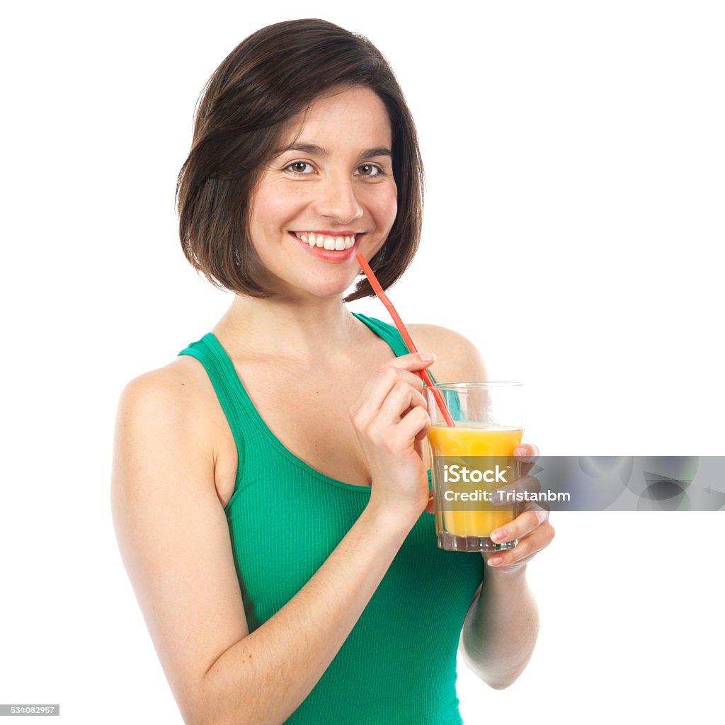 Pretty brunette and orange juice Portrait of a woman drinking an orange juice with a straw, isolated on white 2015 Stock Photo