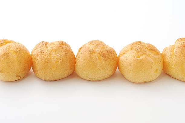 istock Cream puffs in a line isolated on white background 534083273