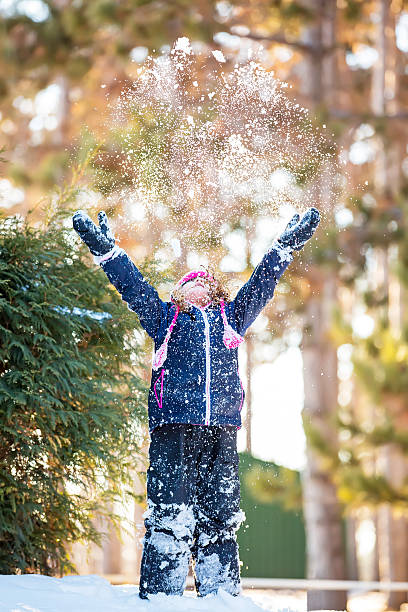 istock Young Girl Throwing Snow in the Air 534084675