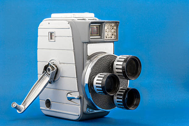 Old three-lens 8mm video camera Studio shot of an old three-lens 8mm video camera on a blue background vintage movie projector stock pictures, royalty-free photos & images