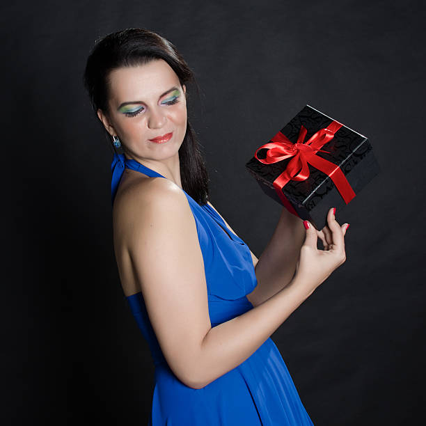 istock Elegant beautiful woman presenting a gift box 534085345