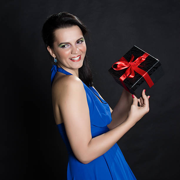 istock Elegant beautiful woman presenting a gift box 534085347