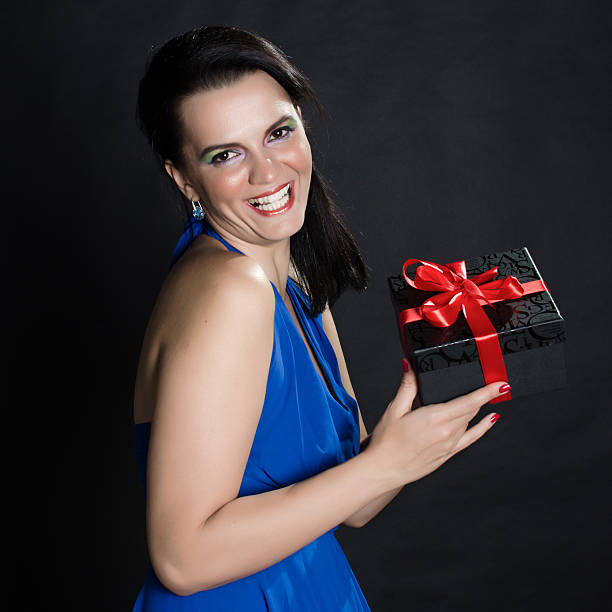 istock Elegant beautiful woman presenting a gift box 534085349