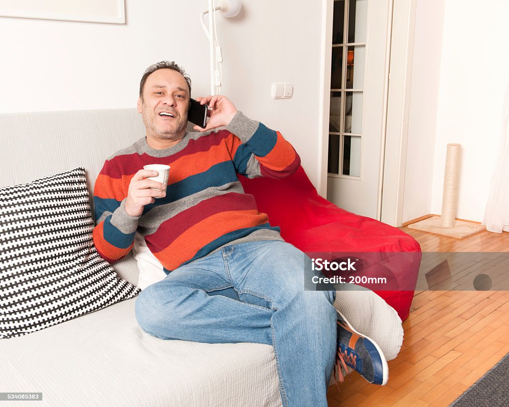 Man talking on the phone Man using smartphone on sofa 2015 Stock Photo