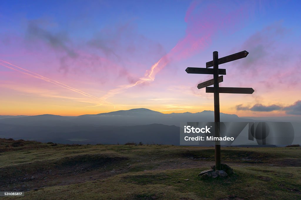 wooden signpost on mountain wooden signpost on mountain at sunset Directional Sign Stock Photo