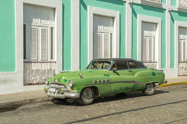 istock Old green car in front of a mint green building 534098431